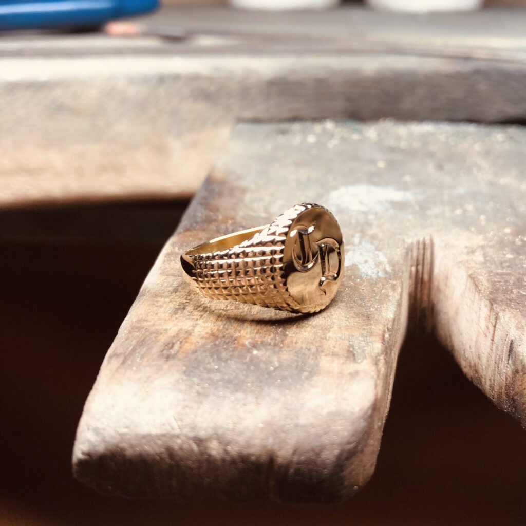 chevalière en or jaune avec un plateau lettré et les flans quadrillés, inspiration d'un briquet dupont