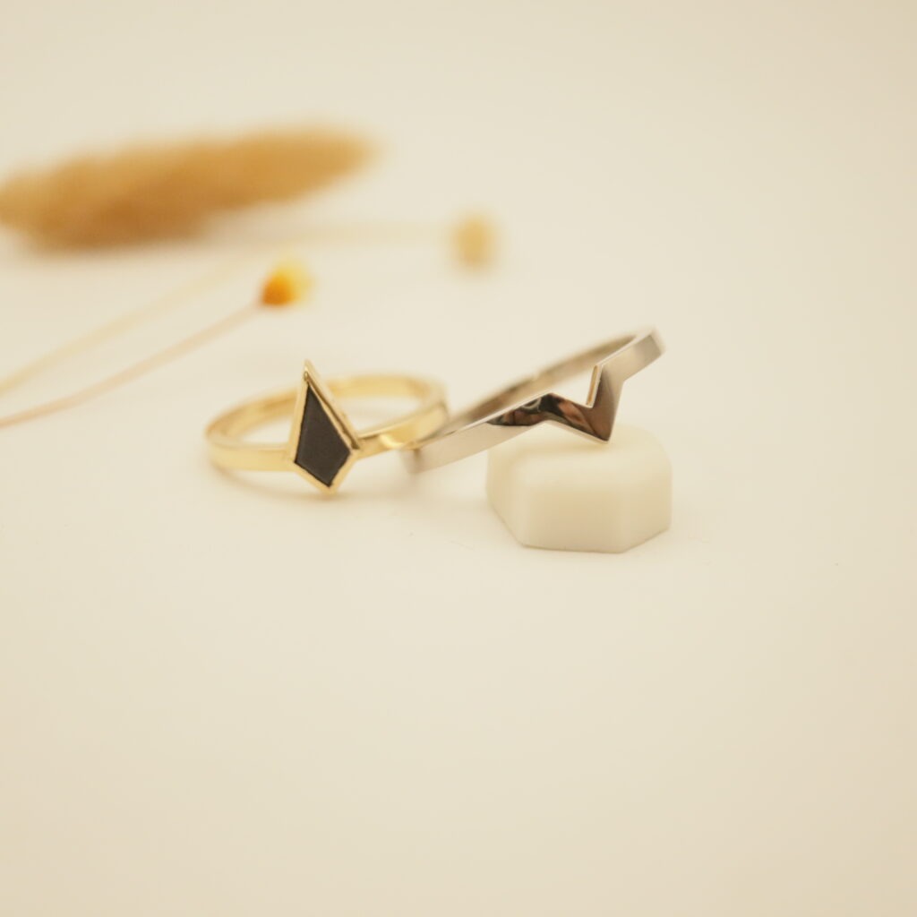 création sur-mesure d'une paire d'alliances avec une porcelaine noire de forme kite en or jaune. L'autre alliance en or blanc s'imbrique parfaitement dans la première