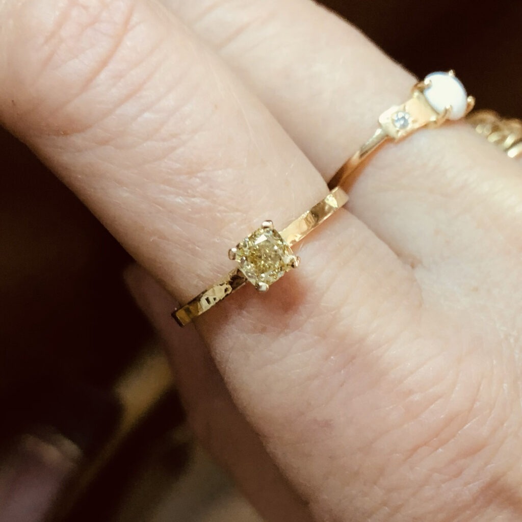 bague solitaire en or jaune martelé avec un diamant jaune de forme coussin